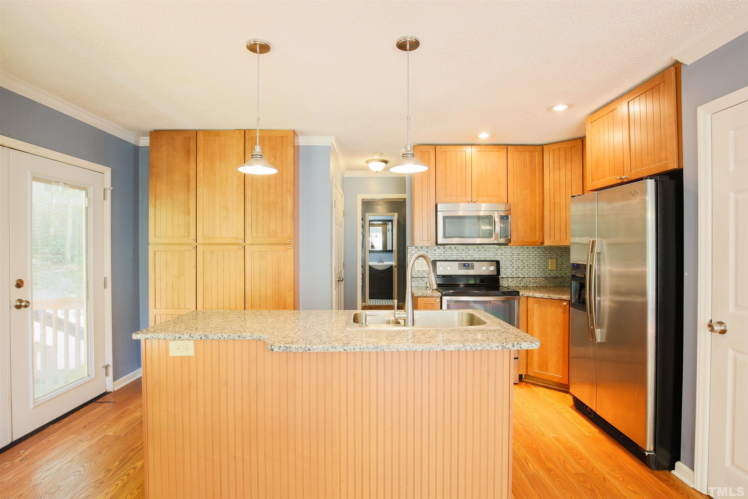 115 Kingsmill Road Cary, NC 27511 - Photo 4 of 19 a large kitchen with stainless steel appliances kitchen island granite countertop a refrigerator and a sink