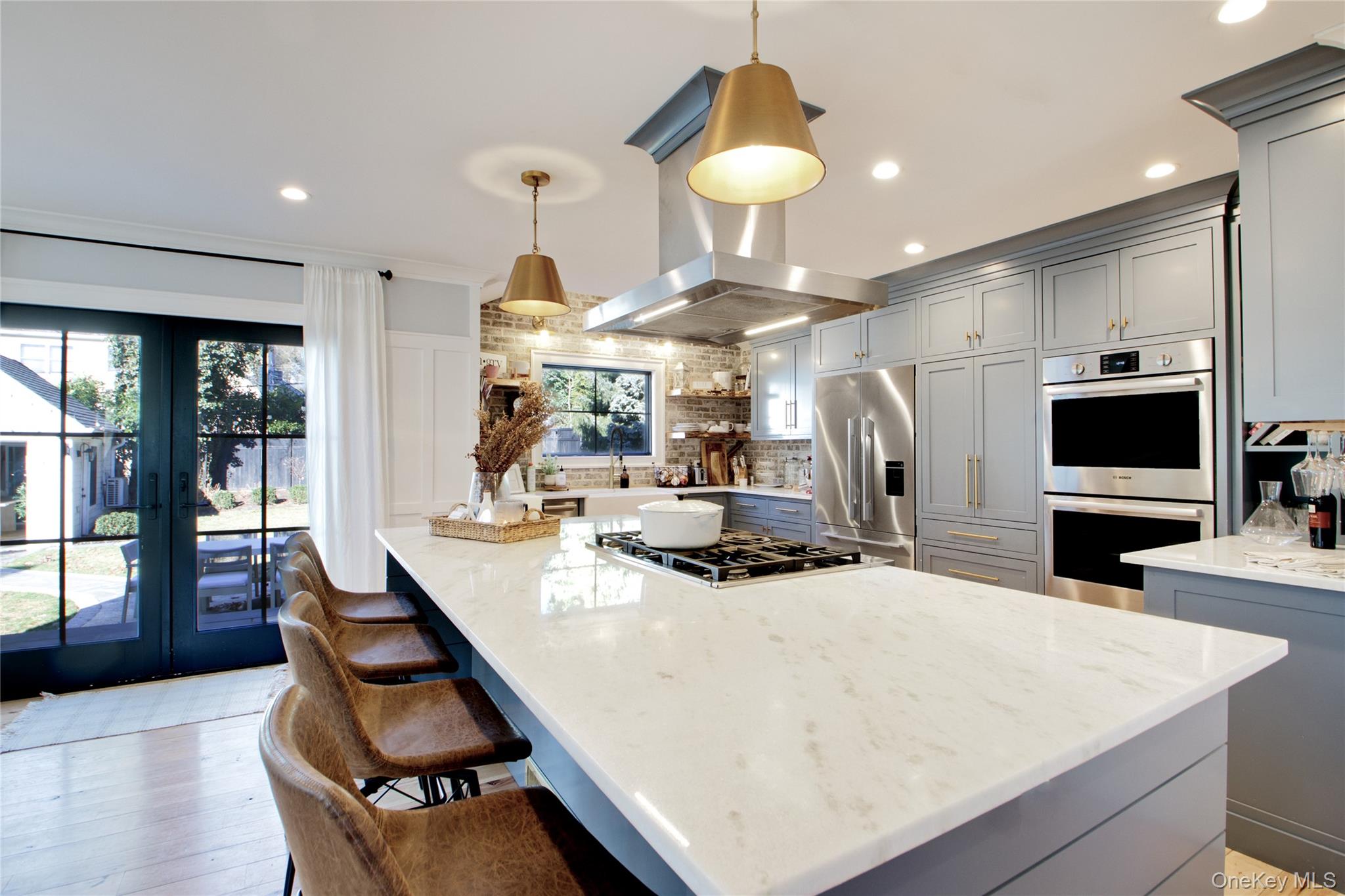 97 Bar Beach Road Port Washington, NY 11050 - Photo 14 of 28 a kitchen with stainless steel appliances kitchen island granite countertop a stove a oven a sink a dining table and chairs with wooden floor