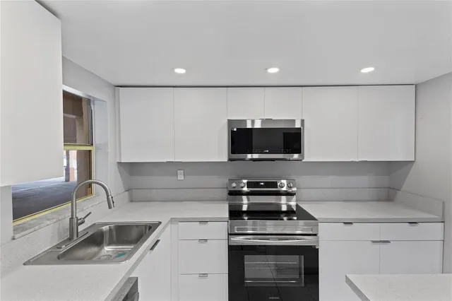 a kitchen with a sink a stove and microwave