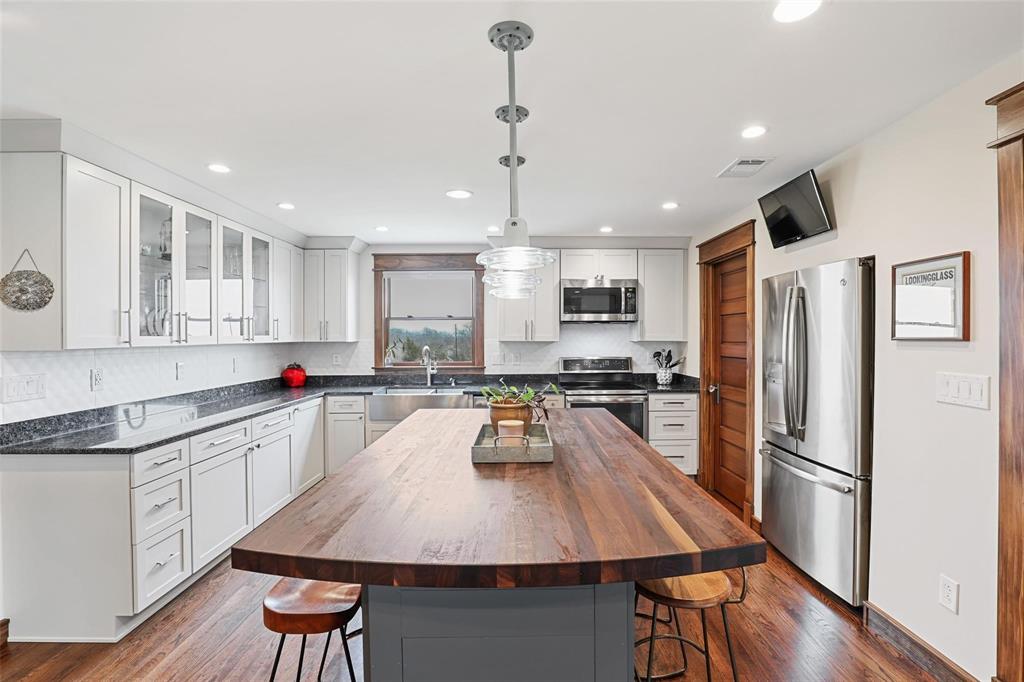 2196 Bledsoe Road Gunter, TX 75058 - Photo 12 of 33 a kitchen with counter space dining table and stainless steel appliances