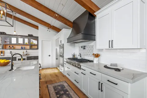 a kitchen with stainless steel appliances kitchen island granite countertop a table chairs and a refrigerator