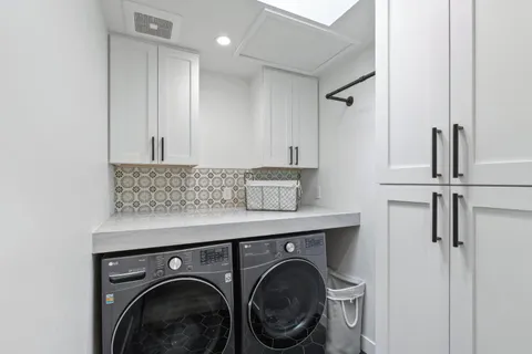 an aerial view of a city with lots of residential buildings ocean and mountain view in back