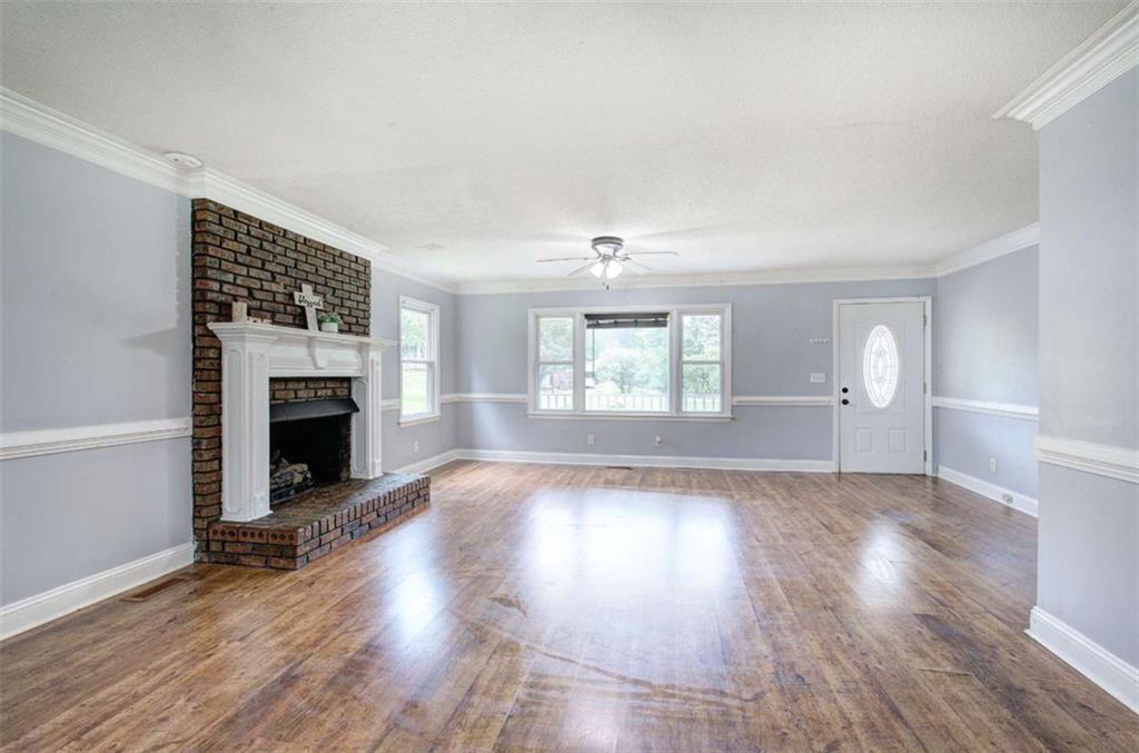 60 Lee Street Rockmart, GA 30153 - Photo 4 of 21 an empty room with windows a fireplace and wooden floor