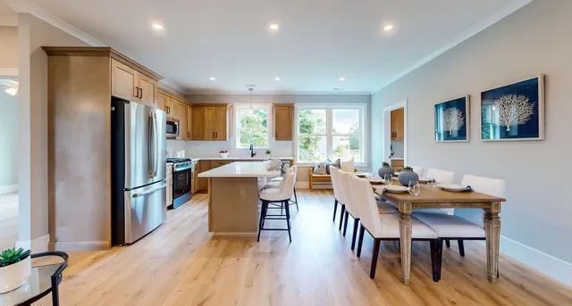 a kitchen with sink a refrigerator a table and chairs