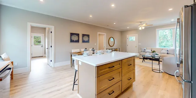 a kitchen with a stove a refrigerator a sink dishwasher with a dining table and chairs with wooden floor