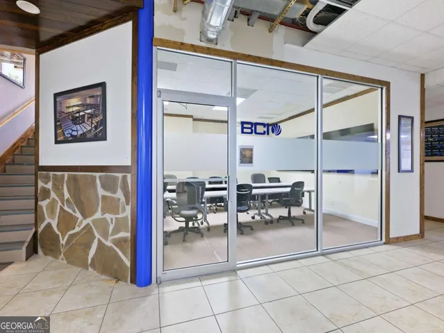 a kitchen with stainless steel appliances a stove a refrigerator a sink a dining table and chairs