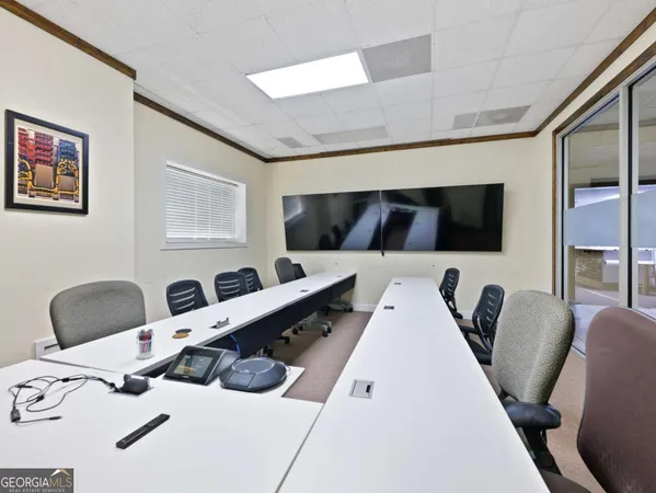 a view of a workspace with furniture and a refrigerator