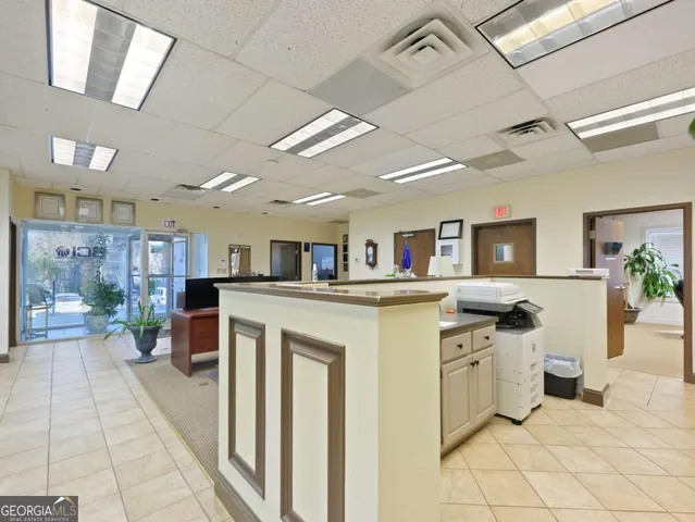 a kitchen with white cabinets appliances and furniture
