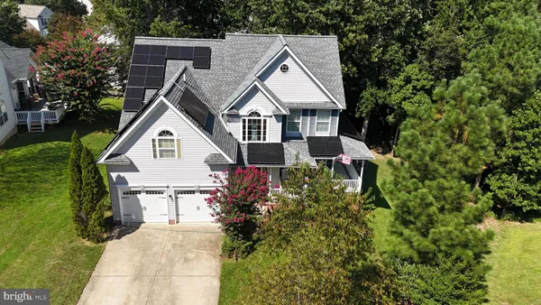 a view of house with garden and tall trees