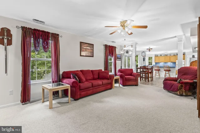 a living room with furniture a ceiling fan and a window
