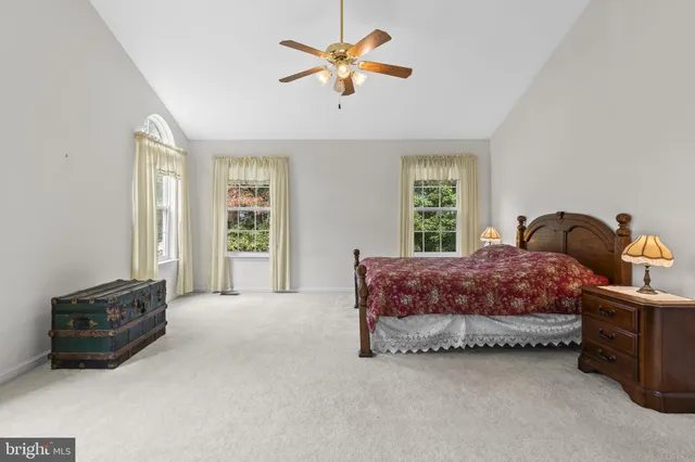 a spacious bedroom with a bed a window and a chandelier