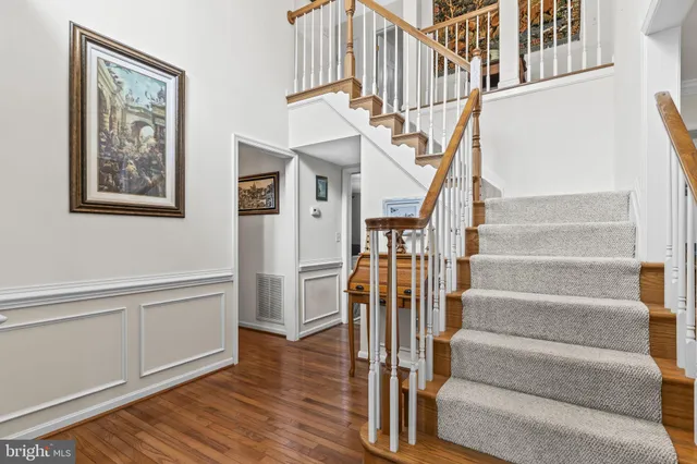 a view of staircase with lots of frames and frames on wall with wooden floor