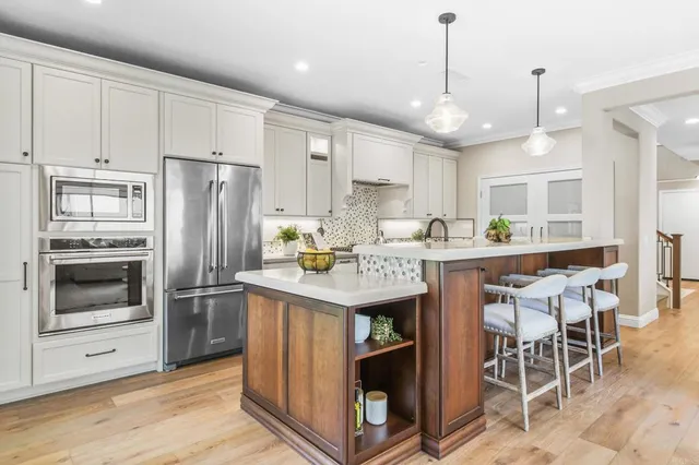 a kitchen with kitchen island granite countertop a sink appliances a counter space and cabinets