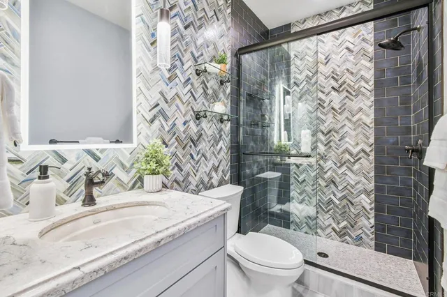 a bathroom with a granite countertop sink toilet and shower