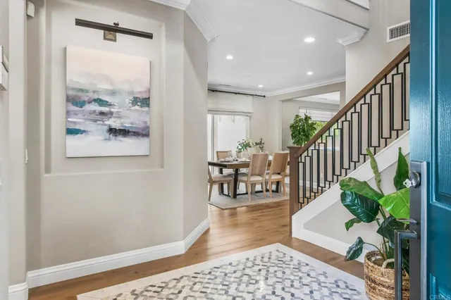 a living room with wooden floor and a potted plant