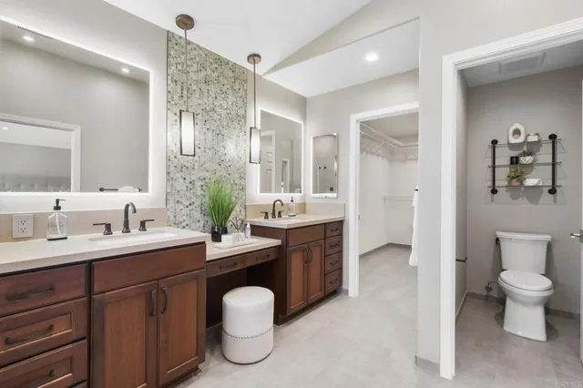 a spacious bathroom with a double vanity sink toilet and a mirror