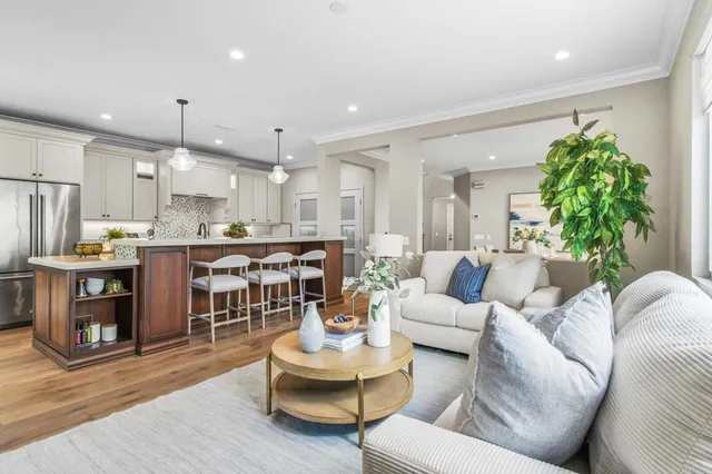 a living room with furniture kitchen and a chandelier