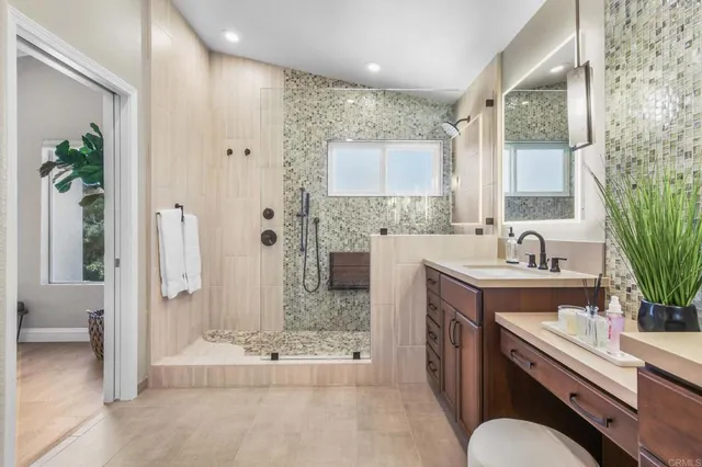 a spacious bathroom with a granite countertop sink mirror and shower