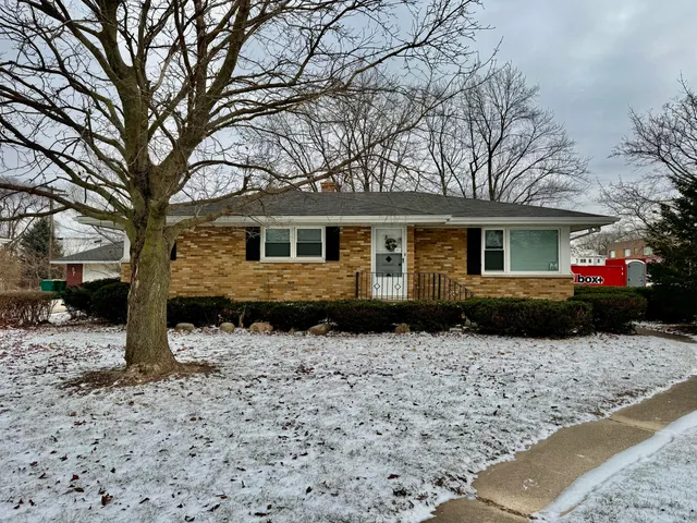 a front view of a house with a yard covered in snow