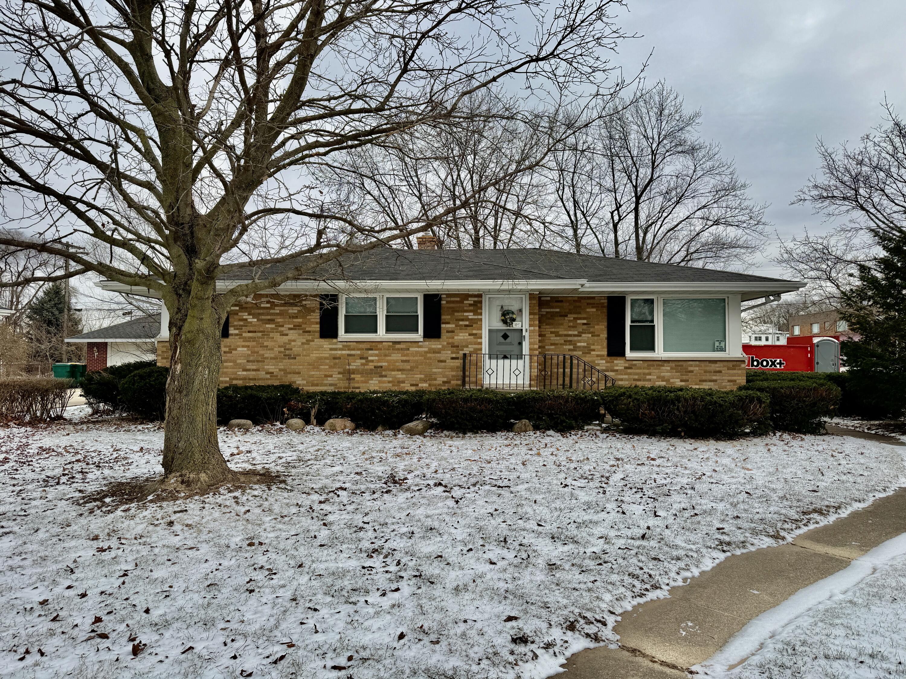 a front view of a house with a yard covered in snow