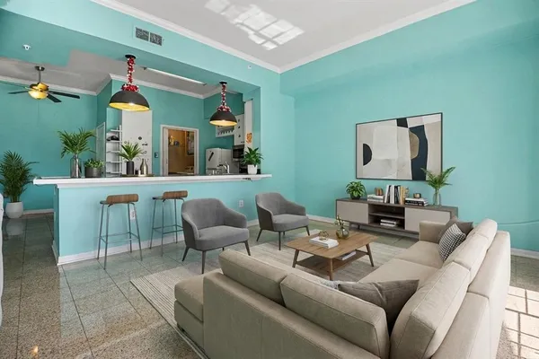 a living room with furniture flowerpot and a chandelier