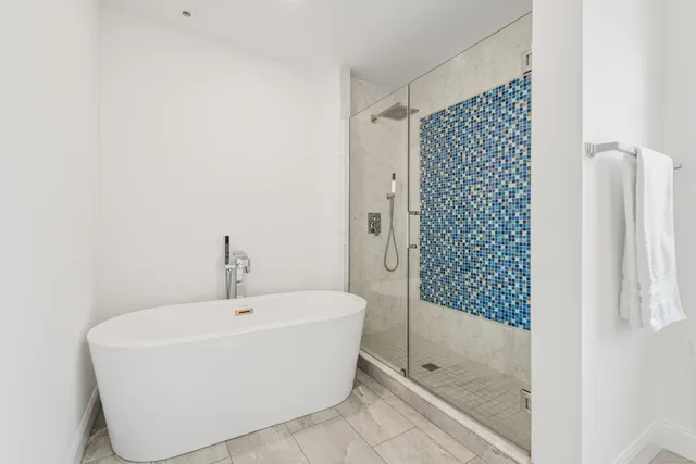 a white bath tub sitting next to a shower