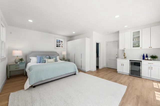 a spacious bedroom with a bed and a cabinets