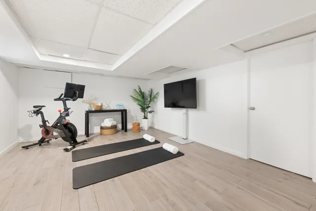 a view of a room with gym equipment and a flat screen tv