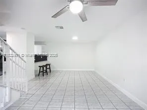 an empty room with a ceiling fan and window