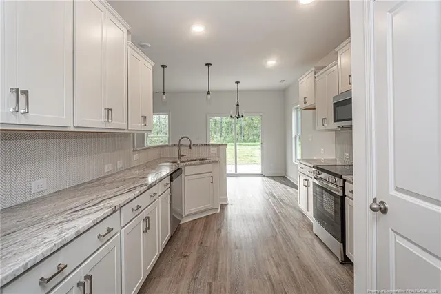a kitchen with stainless steel appliances granite countertop a stove and a refrigerator