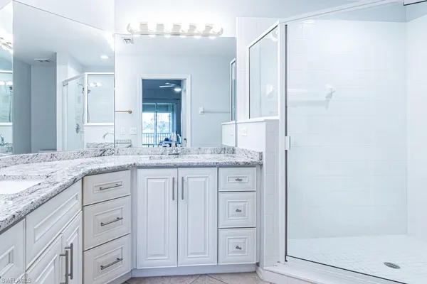 a bathroom with a granite countertop sink a toilet and shower