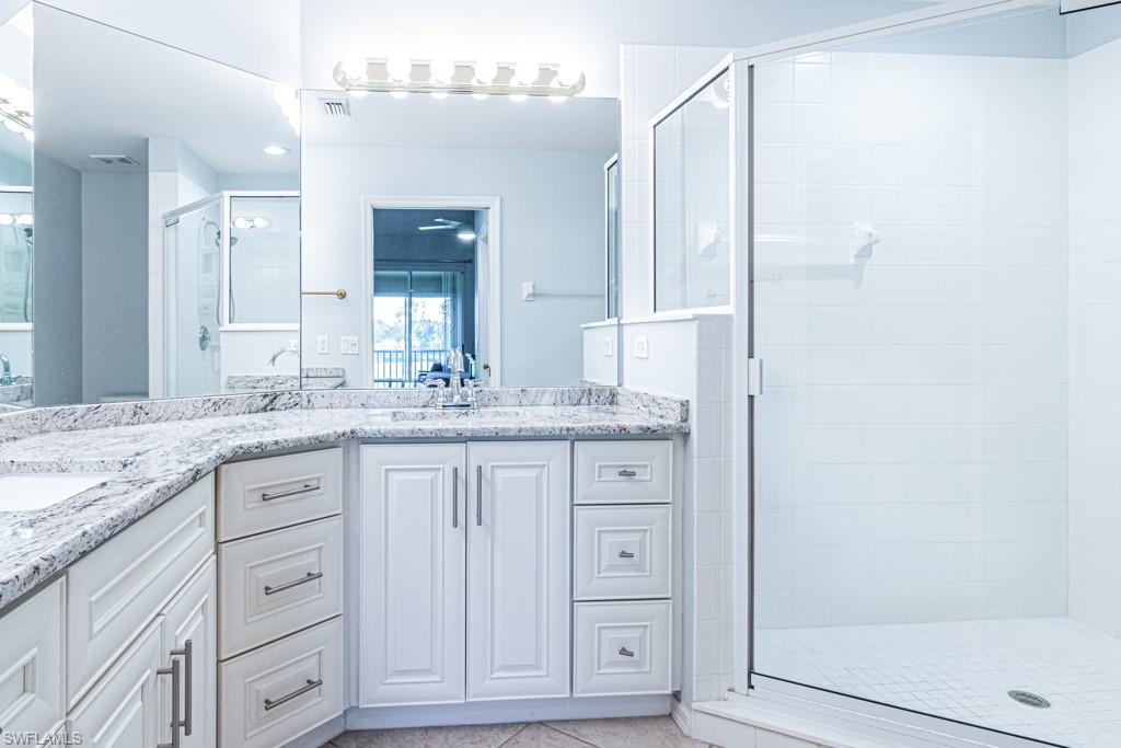 6015 Pinnacle Lane, Unit 5 Naples, FL 34110 - Photo 14 of 25 a bathroom with a granite countertop sink two mirror and shower