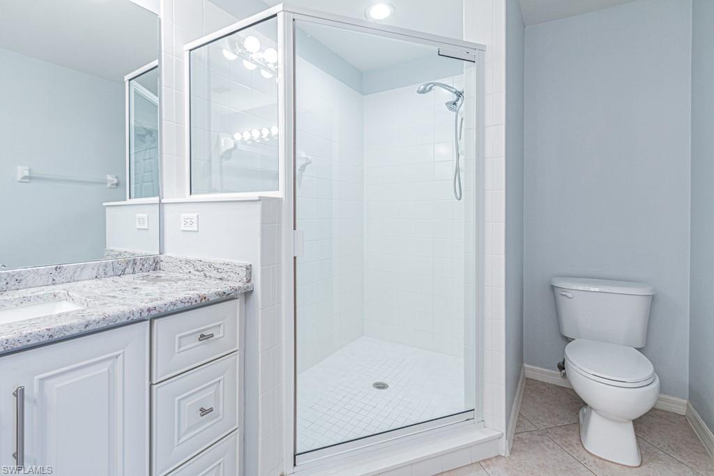 6015 Pinnacle Lane, Unit 5 Naples, FL 34110 - Photo 15 of 25 a bathroom with a granite countertop sink a toilet and shower