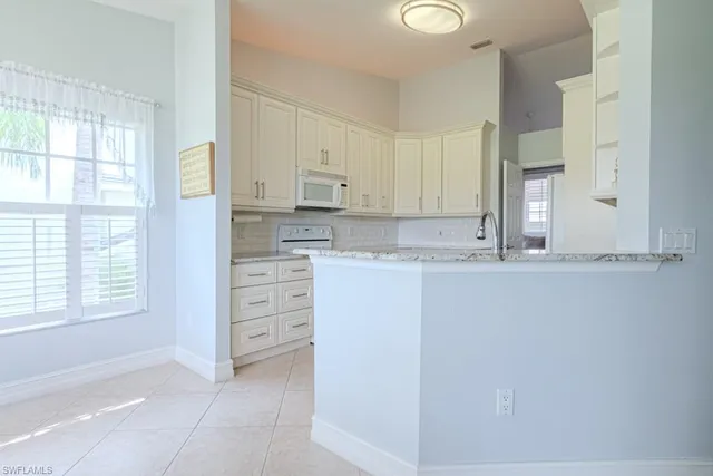 a kitchen with cabinets and white stainless steel appliances