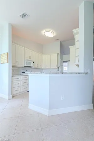 a kitchen with granite countertop a sink a stove and cabinets