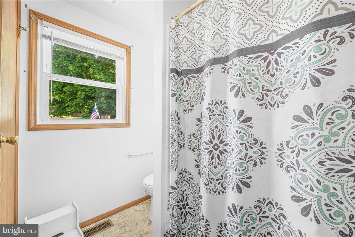 14011 Pryor Road Thurmont, MD 21788 - Photo 19 of 38 a bathroom with a window and a shower curtain