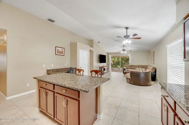 a kitchen with stainless steel appliances granite countertop a sink dishwasher and a stove with wooden floor