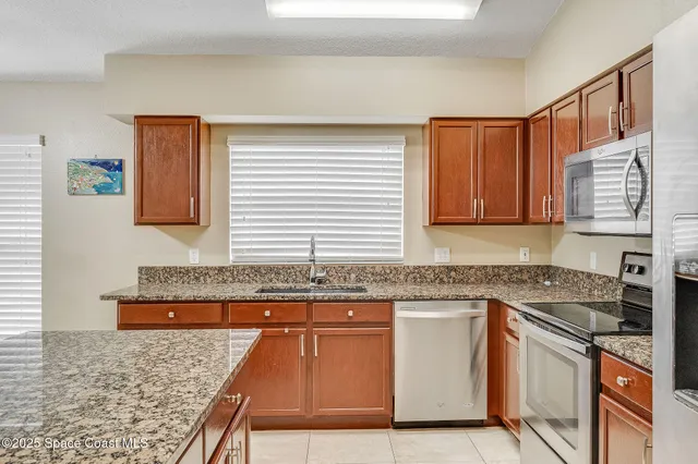 a kitchen with stainless steel appliances granite countertop a sink stove and cabinets