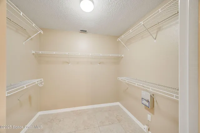 a view of walk in closet with empty racks