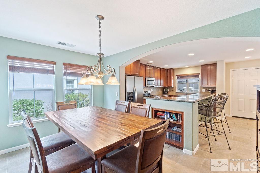 7686 Pebblestone Way Reno, NV 89523 - Photo 20 of 35 a dining area with furniture a rug and a chandelier