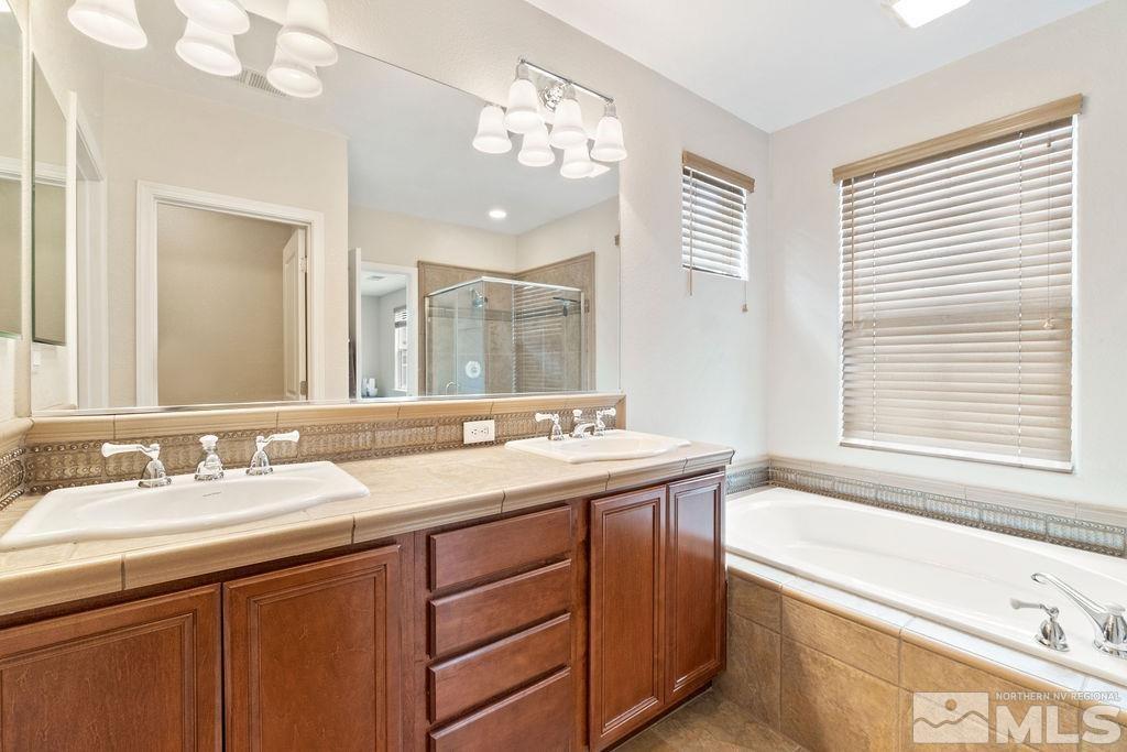 7686 Pebblestone Way Reno, NV 89523 - Photo 27 of 35 a bathroom with a tub double vanity sink and mirror