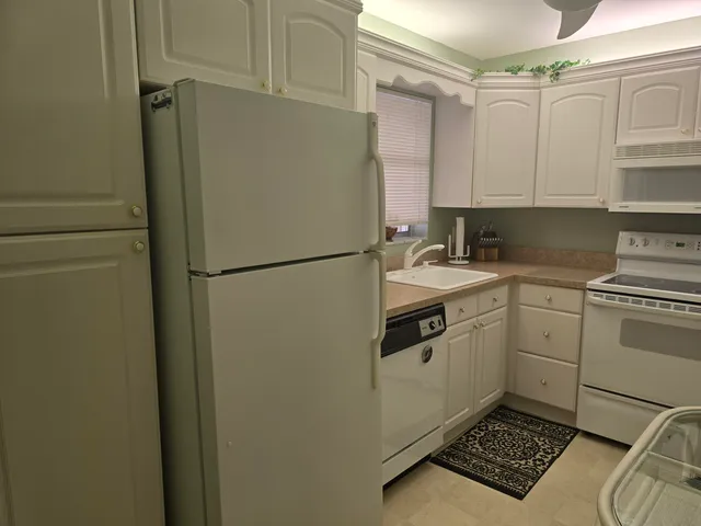 a kitchen with a refrigerator sink stove and cabinets