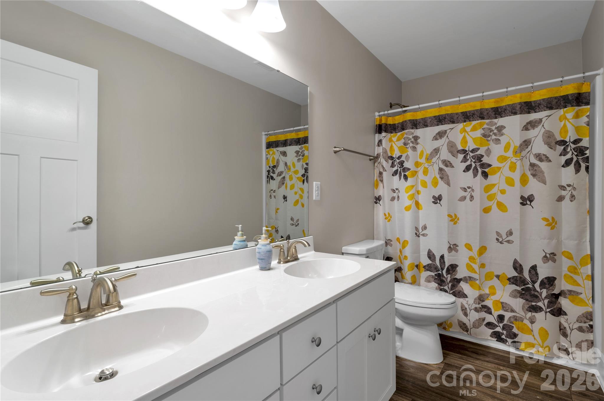 27 Mann Lane Fletcher, NC 28732 - Photo 16 of 25 a bathroom with a granite countertop sink a toilet and shower curtain