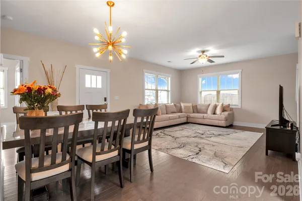 a living room with furniture a chandelier a rug and a window