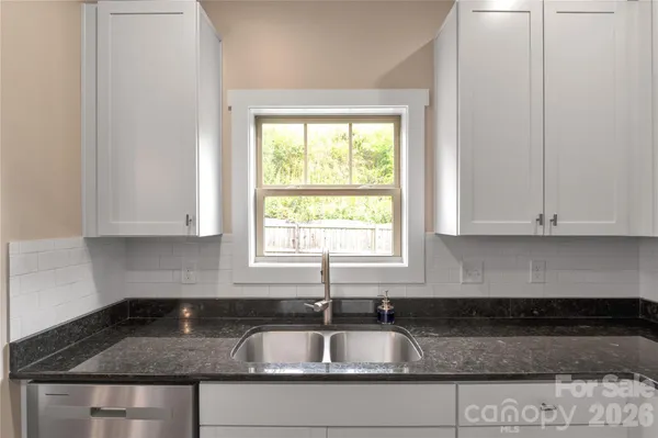 a kitchen with granite countertop a sink and a window
