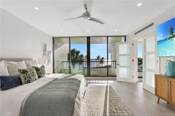 a large bedroom with a large bed and a view of living room
