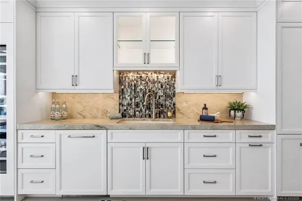 a kitchen with granite countertop white cabinets and white appliances