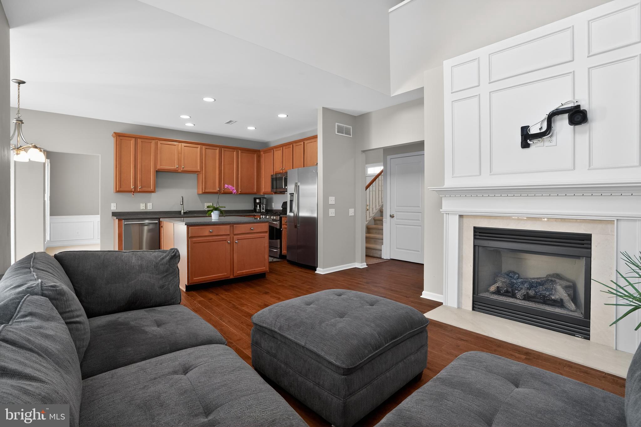 694 Churchill Road Chester Springs, PA 19425 - Photo 16 of 49 a living room with stainless steel appliances furniture a fireplace and a kitchen view