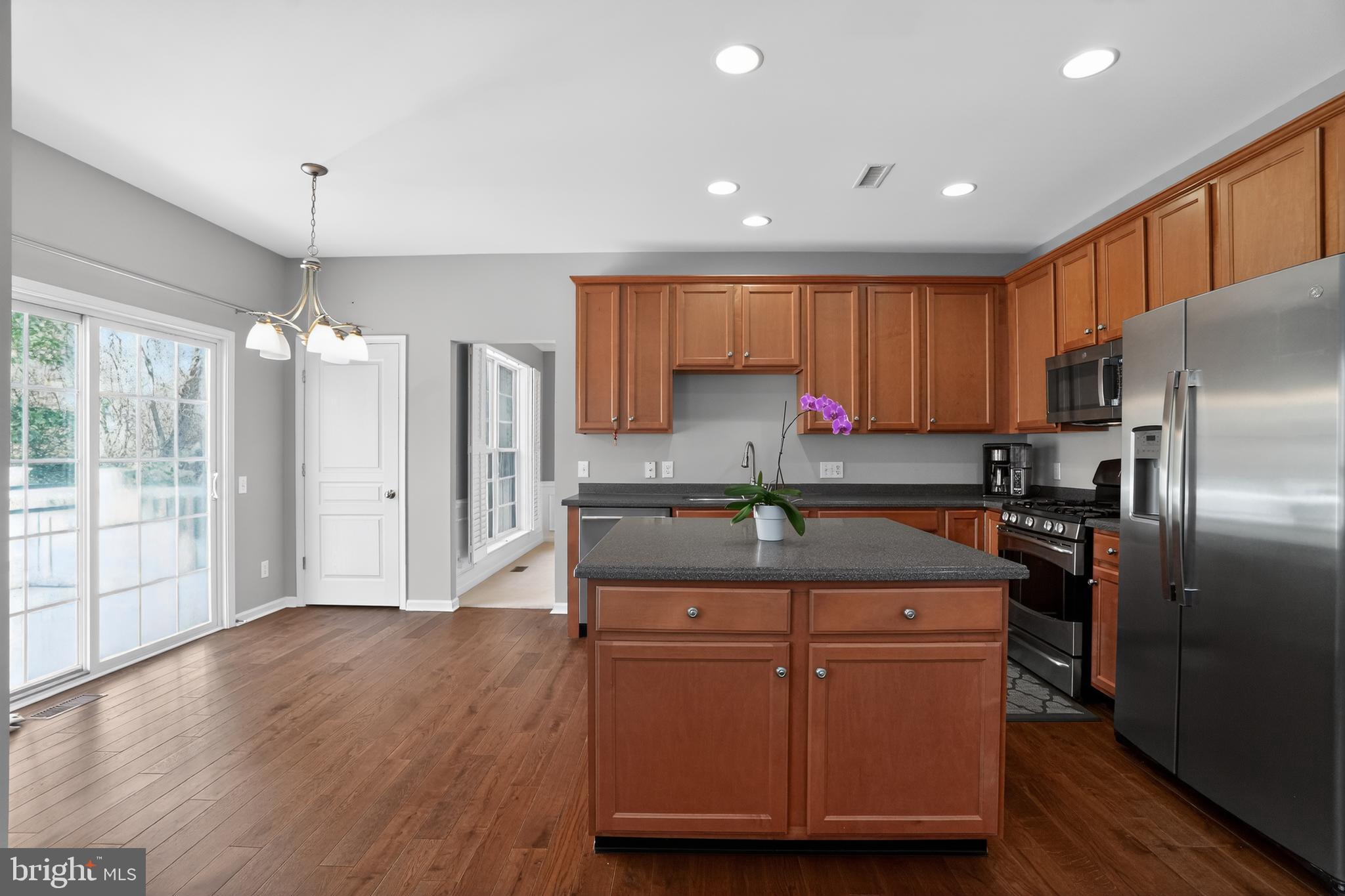 694 Churchill Road Chester Springs, PA 19425 - Photo 20 of 49 a kitchen with kitchen island granite countertop wooden cabinets and a refrigerator