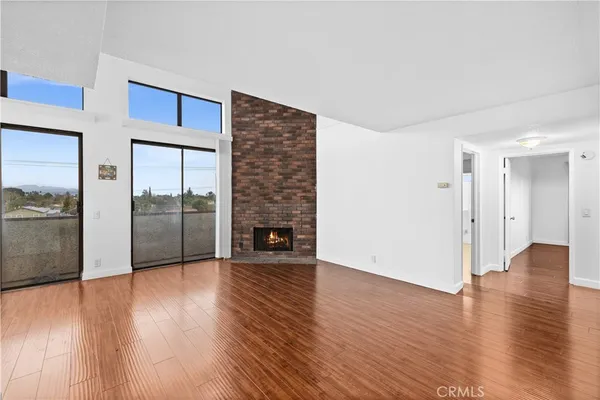 a view of a livingroom with wooden floor and a fireplace